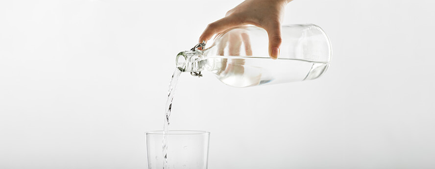 Person Pouring Natural Mineral Or Tap Water From Clear Bottle In Glass Hydration Water Drinking