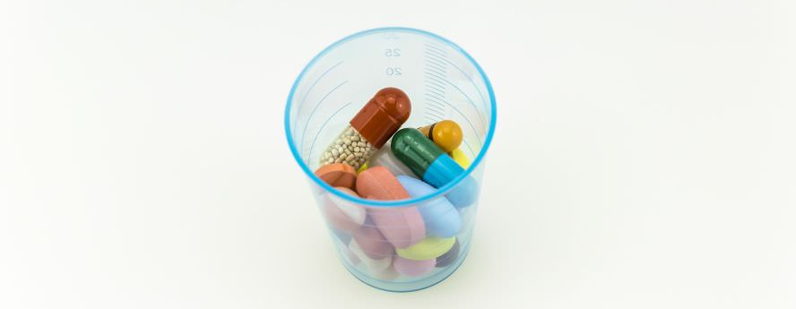 Tablets Pills Antibiotics And Other Medication Drugs In Plastic Measurement Cup