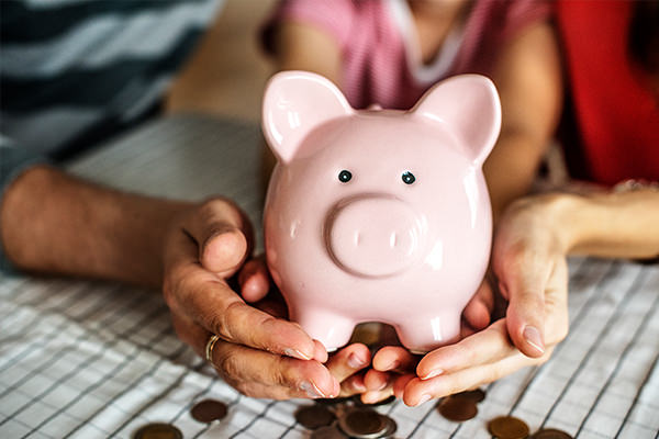 Couple Holding Pink Piggy Bank And Saving Money