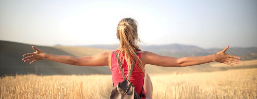 Blond Girls With Arms Wide Open Looking At The Horizon In Hay Field Summer