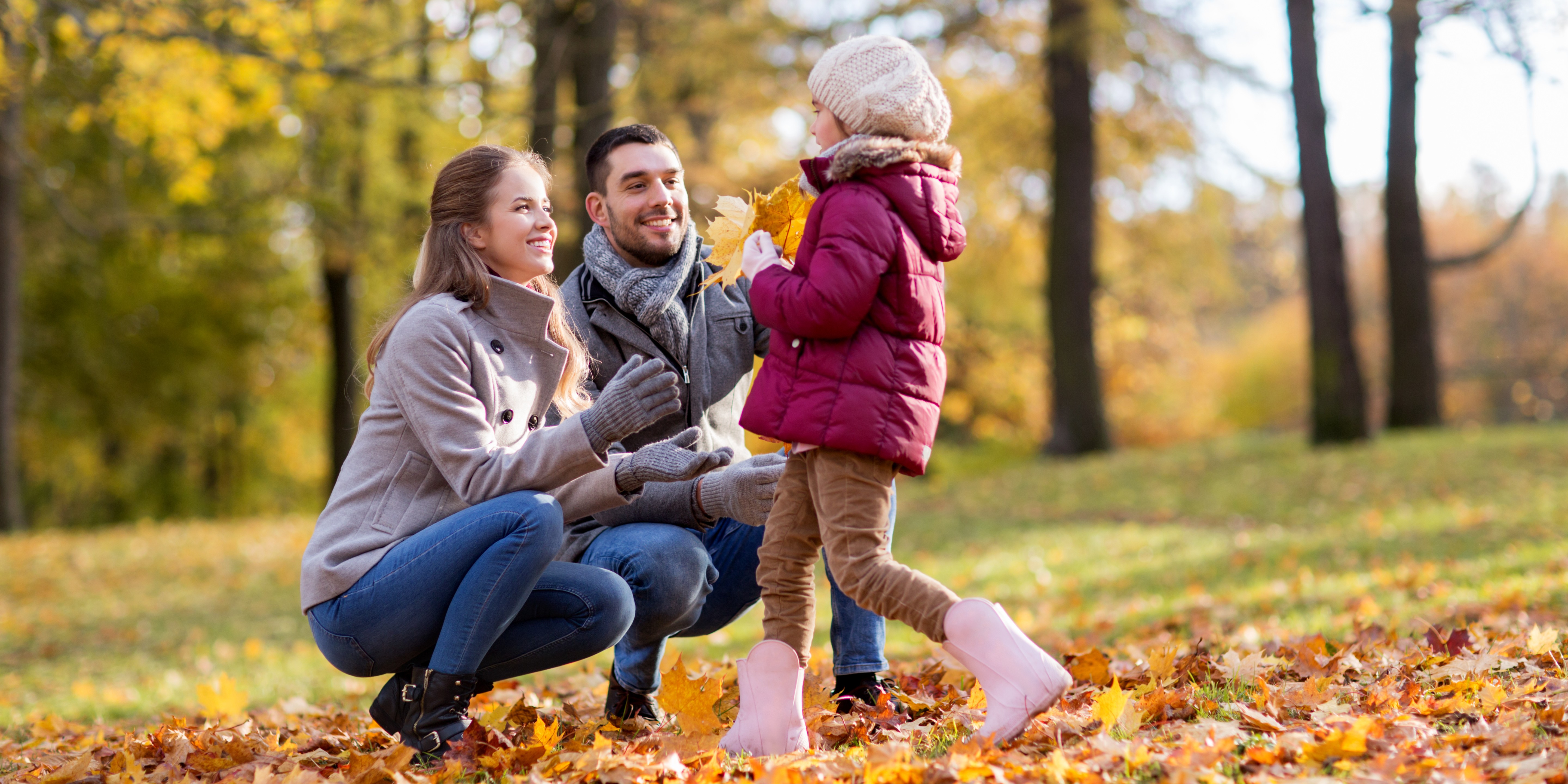 Family enjoying a walk in the park on an autumn day.